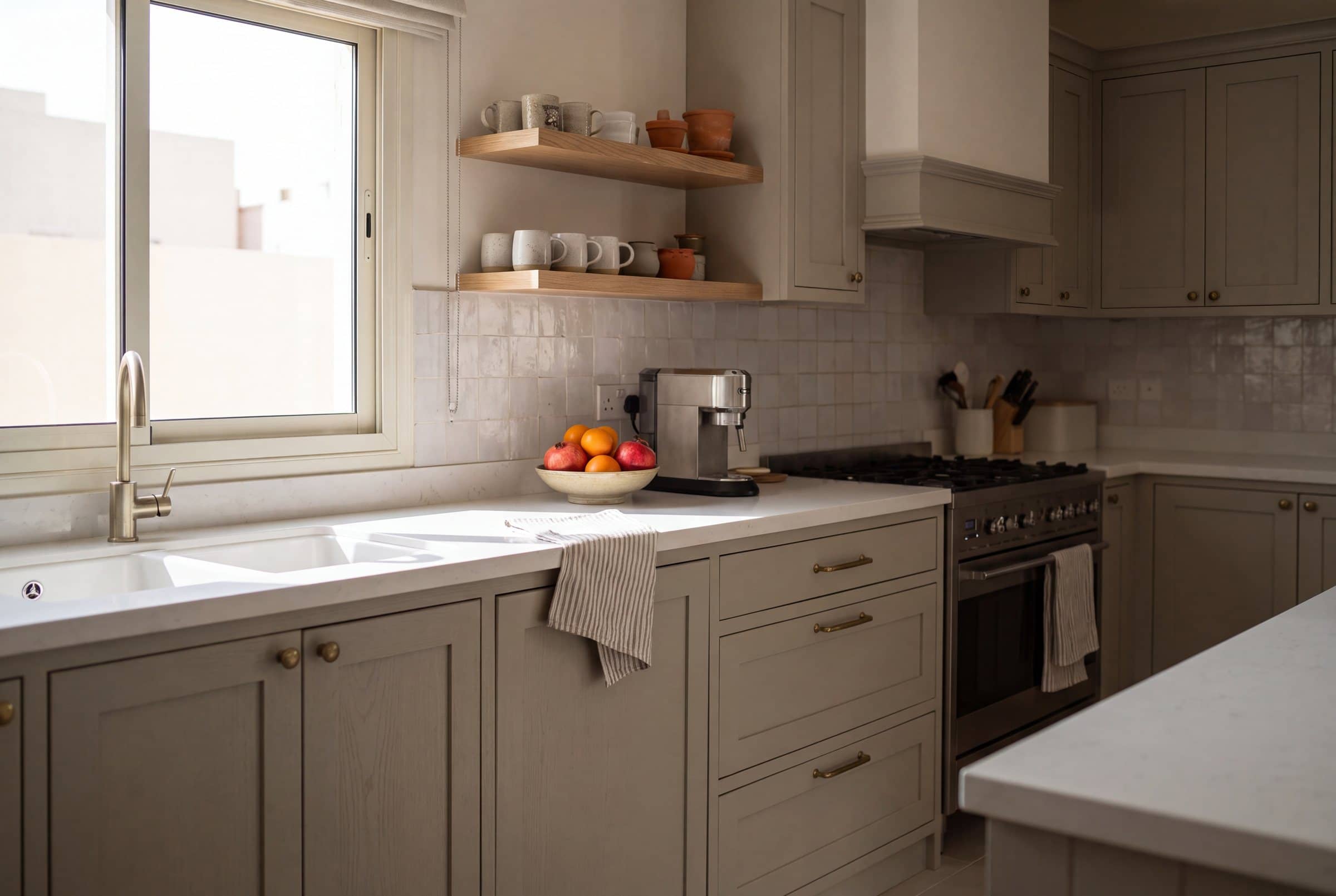 Kitchen with sage-grey shaker doors, brass knobs and handles, open oak shelves and a range cooker